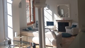 A spacious living room with a glass coffee table, a white sofa, and a fireplace. - Piazza santa croce, uffizzi, luxury apartment in historic building  (Firenze)