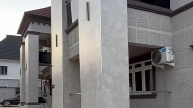 A modern building with a tiled driveway and a car parked in the background. - Downunder Suites (Abuja)