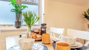 A breakfast table with a coffee maker, croissants, and a vase of tulips. - Delightful recently completed Annexe close to Cambridge. (Cambridge)