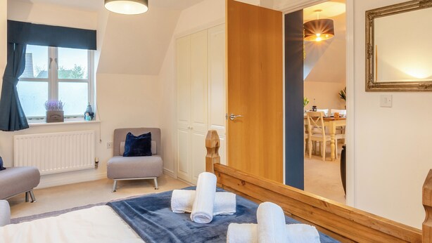 A bedroom with a bed, a chair, a desk, and a large mirror. - Delightful recently completed Annexe close to Cambridge. (Cambridge)