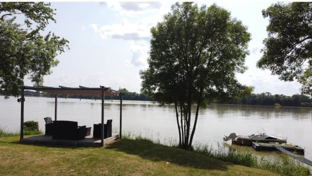 A lakeside deck with outdoor seating and a dock.