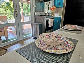 A kitchen with a stove, oven, and a dining area with a patterned table and chairs.
