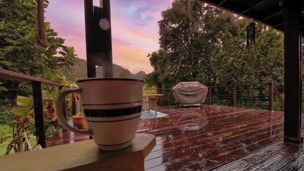 A wooden deck with a railing, a table, and a covered grill area. - Nature Escape, Outdoor Cinema & River Adventure (Lares)