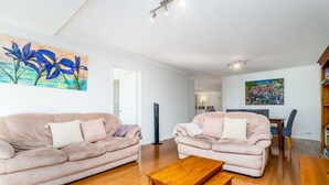 A living room with two sofas, a coffee table, and artwork on the walls.