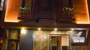 A hotel entrance with a modern design, featuring a dark facade and illuminated entrance. - Vizyon Life Pansiyon (Elazig)