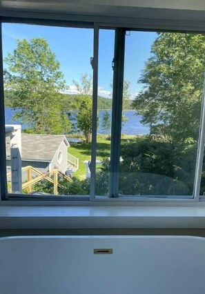 Enjoy a serene view of the lake and surrounding greenery from the large window.