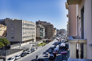 Une vue de rue avec des immeubles, des voitures garées et un ciel dégagé.