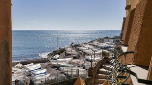 A balcony with a view of the sea, covered boats, and a staircase leading down to the beach. - Casa Camilla al Mare by Wonderful Italy (Genoa)