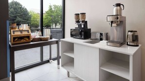 A modern kitchen with a coffee machine, a microwave, and a coffee pot on the counter. - Days Inn By Wyndham Staten Island (Staten Island)