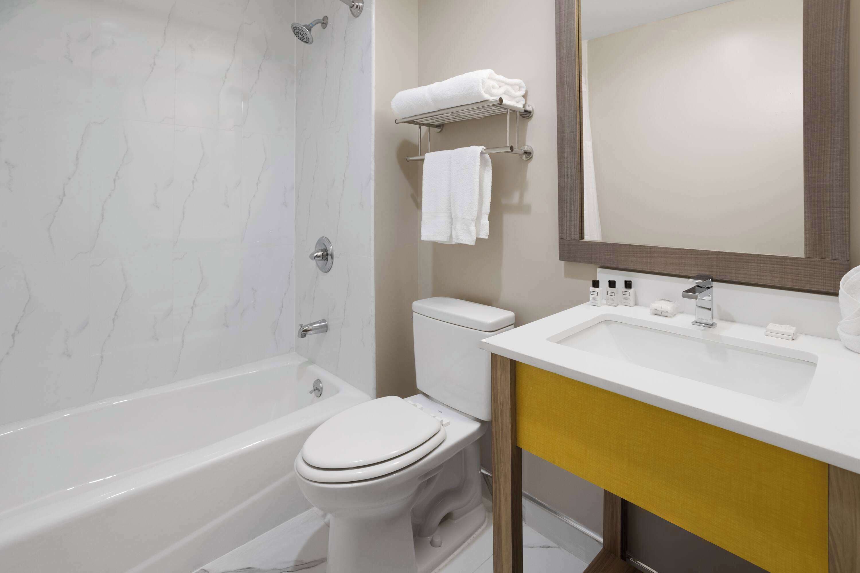 A modern bathroom with a bathtub, toilet, and sink.