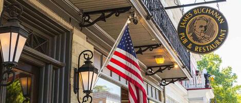 A building with a sign reading "James Buchanan Pub & Restaurant" and an American flag.
