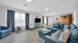 A modern living room with a blue sofa, a green entertainment unit, and a wooden cabinet. - Walk to bar, shop, and DT (Port Sanilac)