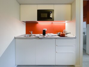 Køleskab, mikrobølgeovn, køkkentøj/tallerkener/redskaber, spisebord