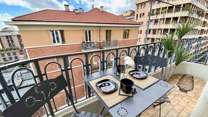 A balcony with a table set for two, a chair, and a small potted plant. - Urban Jungle apt - Self Check-in, Metro, Train (Torino)