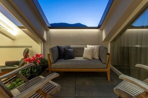 A cozy seating area with a cushioned bench, wooden chairs, and a potted plant. - Roof Garden Cavour - Design and comfort/Parking (Como)