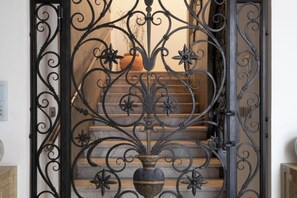 A wrought iron gate with a floral design leading to a staircase. - Roof Garden Cavour - Design and comfort/Parking (Como)