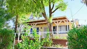 A two-story house with a balcony, surrounded by lush greenery. - Farmhouse Escape w/Mountain Views (Tolleson)