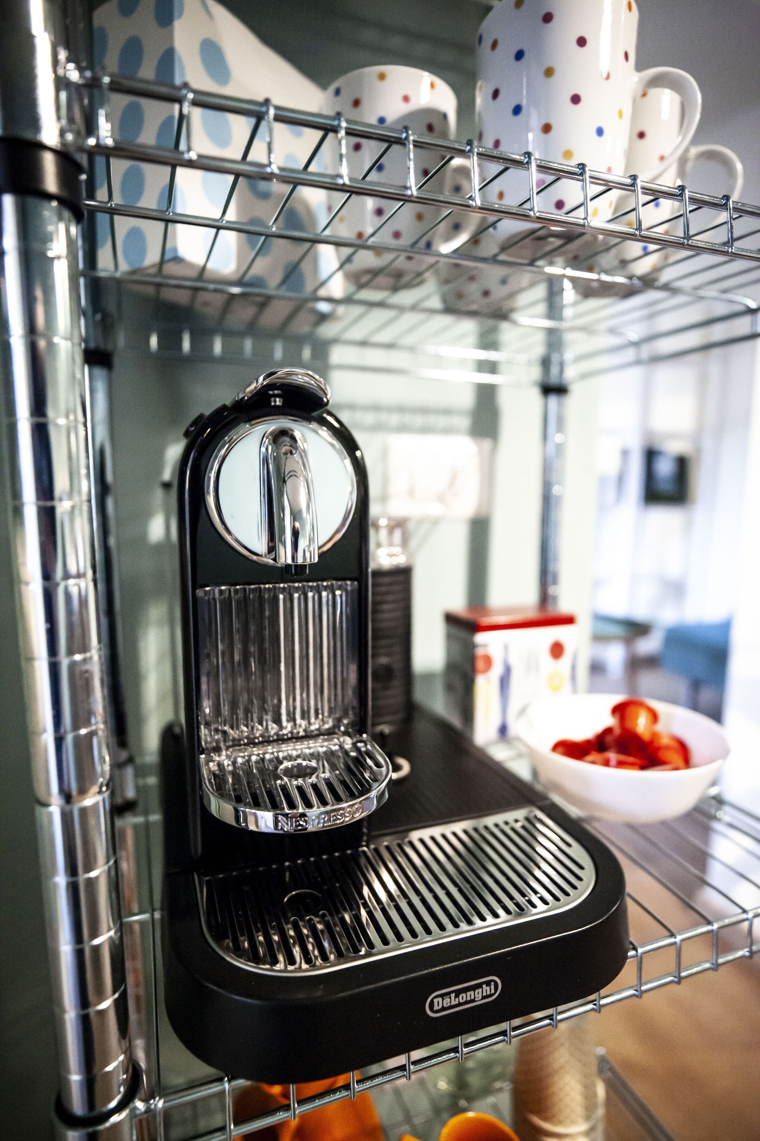 Una máquina de café sobre un estante metálico en una cocina.