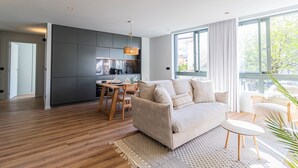 En moderne stue med sofa, spisebord og et køkkenområde.