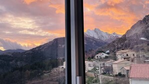 A mountainous landscape with a sunset, houses, and a clear sky. - Appartement Dans la Montagne (Albertacce)