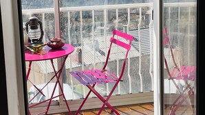 A balcony with a table and chairs, a view of snow-capped mountains, and a tiled floor. - Appartement Dans la Montagne (Albertacce)