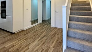 Un intérieur moderne comprenant une cuisine, un escalier et un couloir.