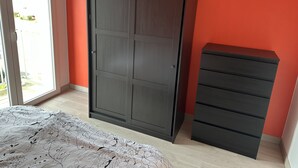 A bedroom with a wardrobe, a dresser, and a bed. - Appartement Le Royal vue Port (Courseulles-sur-Mer)