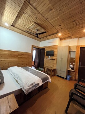 A bedroom with a bed, a wardrobe, a television, and a ceiling fan. - Snow Mount View (Dalhousie)