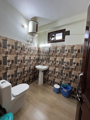 A bathroom with a toilet, sink, and shower. - Snow Mount View (Dalhousie)