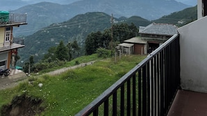A balcony with a view of distant mountains and a cloudy sky. - Snow Mount View (Dalhousie)