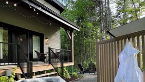 Un bain à remous dans un jardin, avec une terrasse en bois, une maison et une clôture.