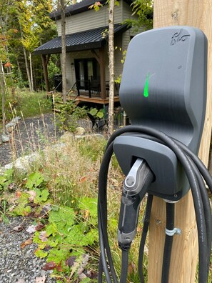 An outdoor electric vehicle charging station attached to a wooden post. - Tiny cottage for 2 -SPA & outdoor -Le EVA (Adstock)