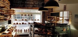 A bakery with various baked goods displayed in glass cases and on shelves.
