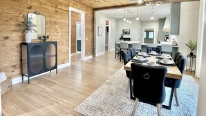 A spacious dining area with a wooden ceiling, a black cabinet, and a dining table set with chairs. - Luxury Home Near Crater of Diamonds 
3 King Beds 2 Full Baths
Sleeps 7 (Nashville)