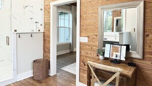 A wooden-paneled room with a wooden desk, a chair, a mirror, and a door leading to another room. - Luxury Home Near Crater of Diamonds 
3 King Beds 2 Full Baths
Sleeps 7 (Nashville)
