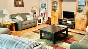 A living room with a sofa, armchairs, a coffee table, a TV, and a wooden cabinet. - Sweet Retreat (Mountain Home)