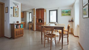 Una cocina amplia con armarios de madera, una mesa de comedor con sillas y piso de baldosas.