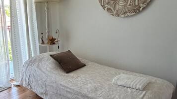 Relax in a serene bedroom with a comfortable bed, a nature-inspired artwork, and a cozy nightstand.