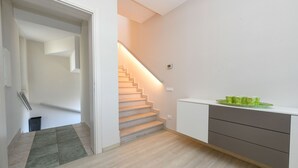 A modern interior with a staircase, a white cabinet, and a green tray on the counter.