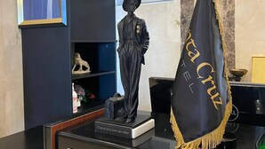 A reception area with a statue, a framed portrait, and a hotel sign. - Hotel Santa Cruz Oran (Oran)