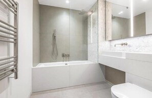 A modern bathroom with a walk-in shower, a bathtub, and a toilet. - Stylish 1-bed Apartment in London (London)