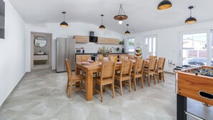 A spacious kitchen with a dining area, wooden furniture, and pendant lighting. - Villa Berg II (Istria - Valbandon) (Valbandon)