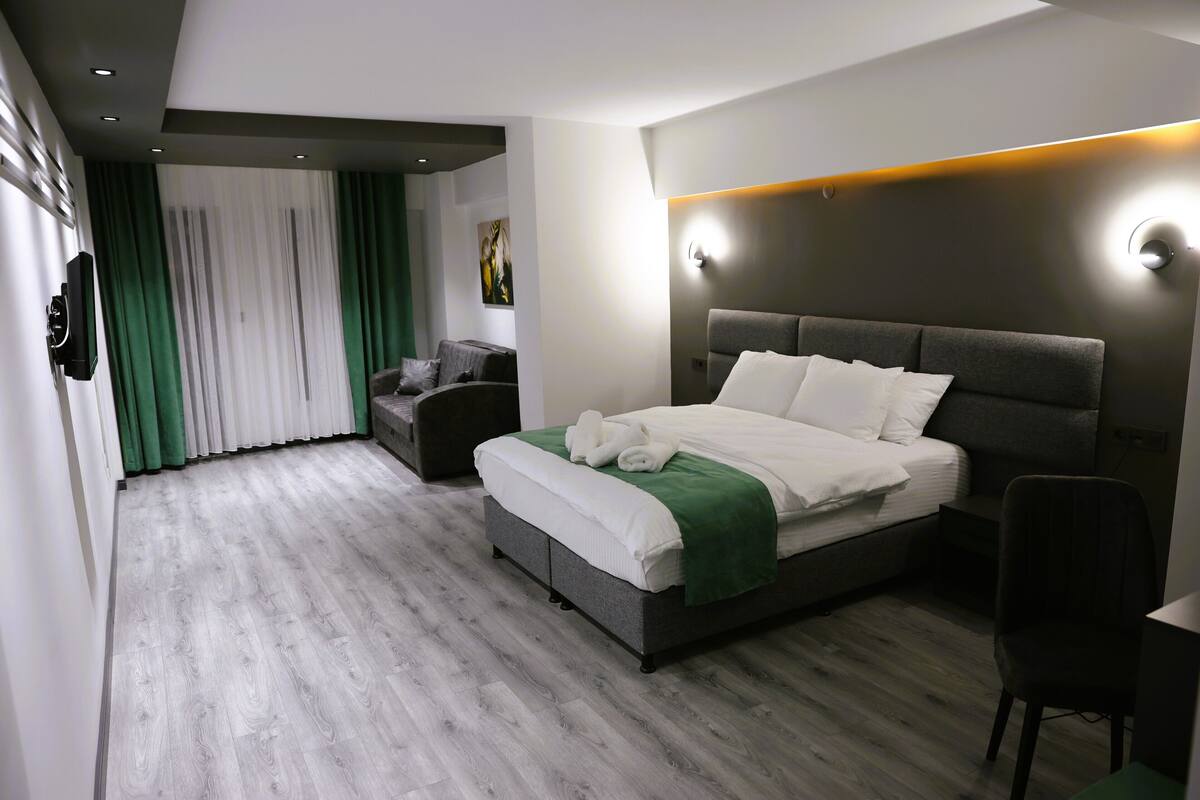 Een moderne hotelkamer met een groot bed, een bureau en een stoel.