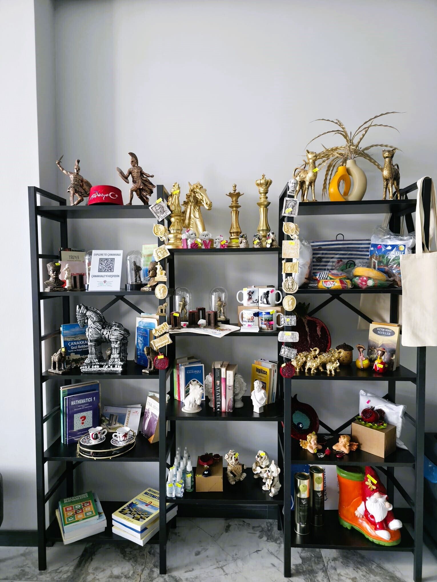 A bookshelf filled with books, decorative items, and a few small figurines.