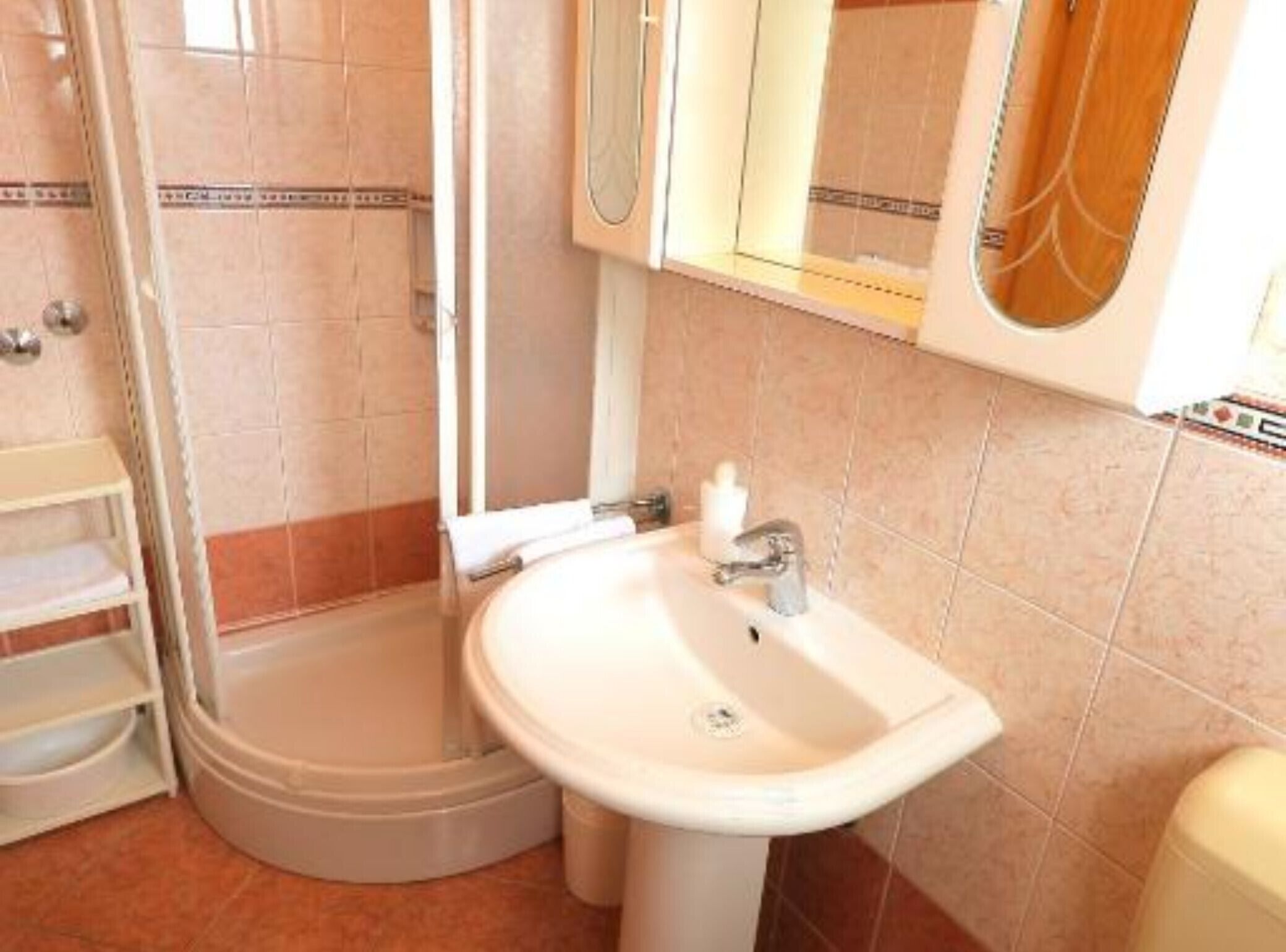 A bathroom with a shower, a sink, and a toilet.