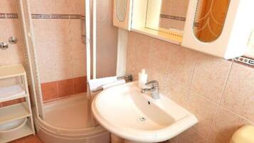 A bathroom with a shower, a sink, and a toilet.