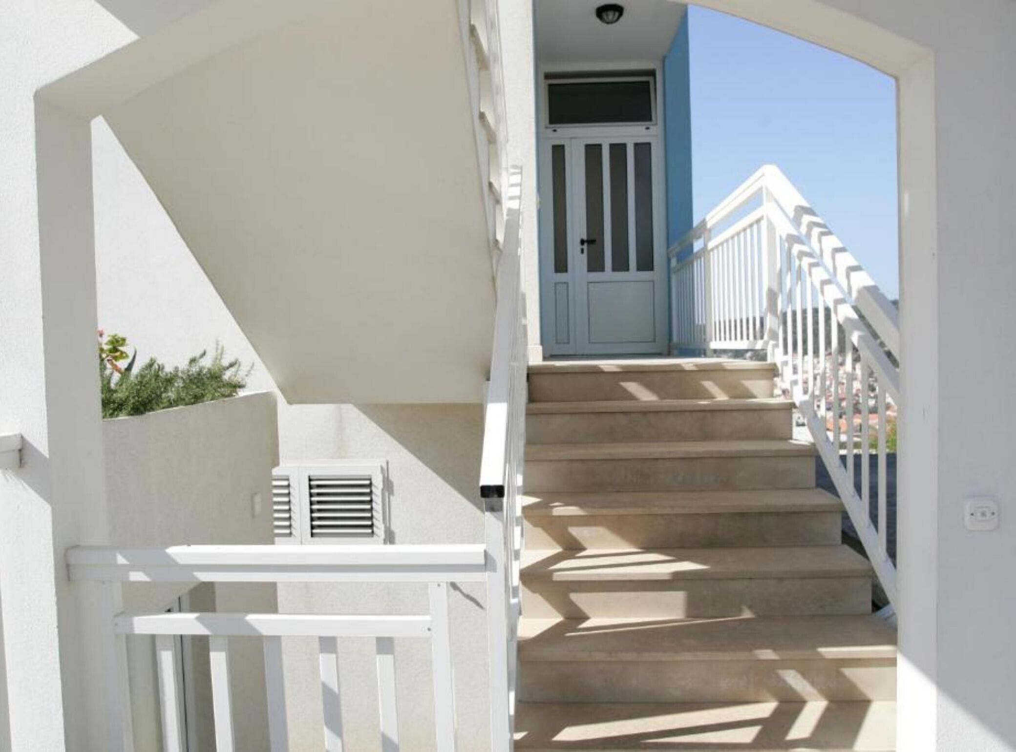 A staircase with white railings leading to a door with a window.