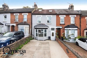 A row of terraced houses with a garage in the middle. - Omega @ Hanwell | Single Room (London)