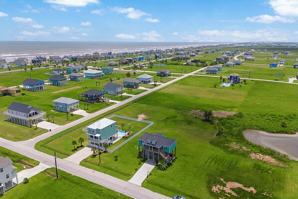 Un quartier résidentiel avec des maisons, des rues et une plage en arrière-plan.