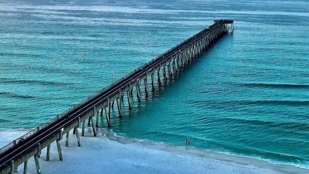 A pier extending into the ocean with clear water and a beach at the end. - Gulf Breeze Retreat#Beaches#vacation rental. (Gulf Breeze)